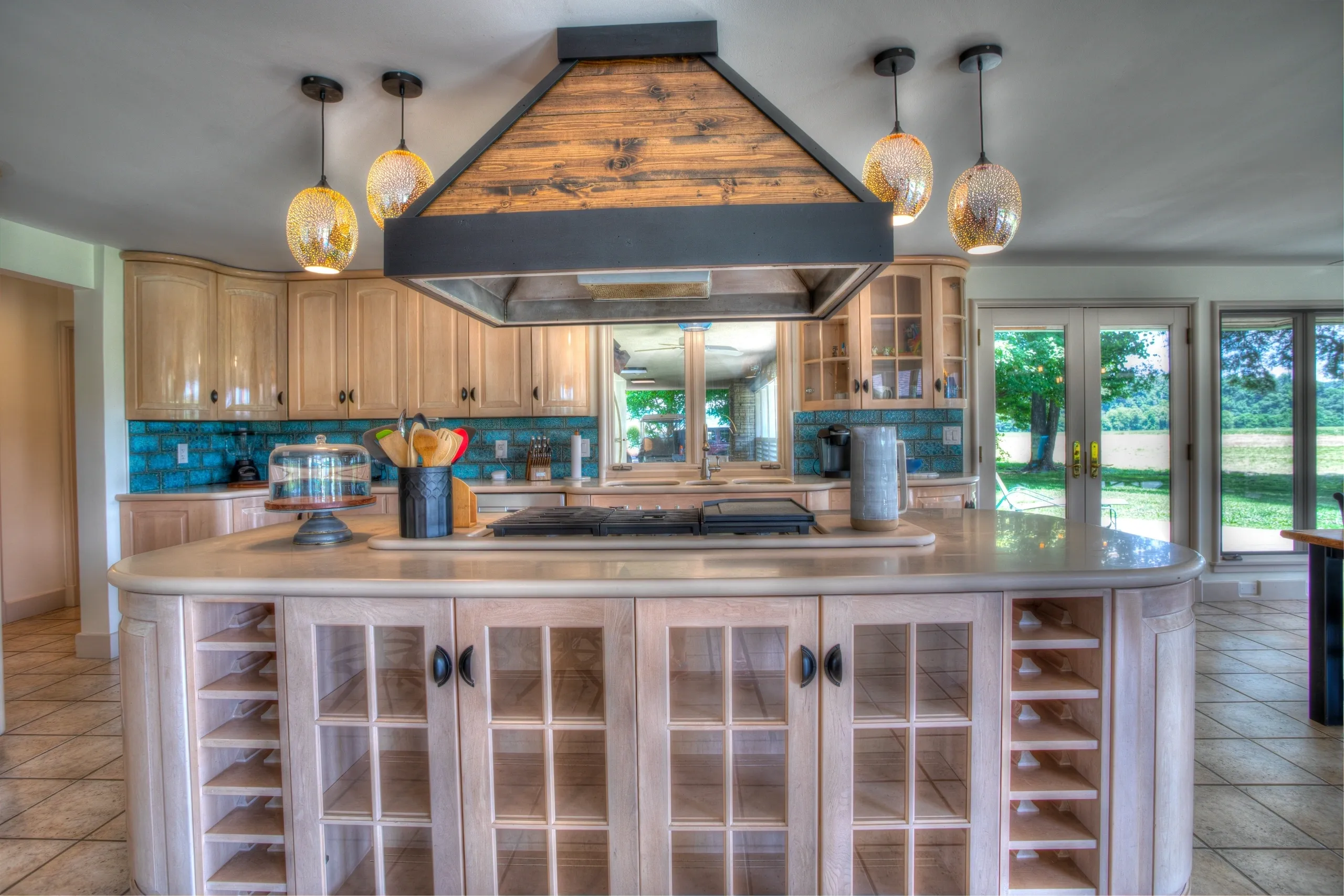 Modern kitchen with island and pendant lights.