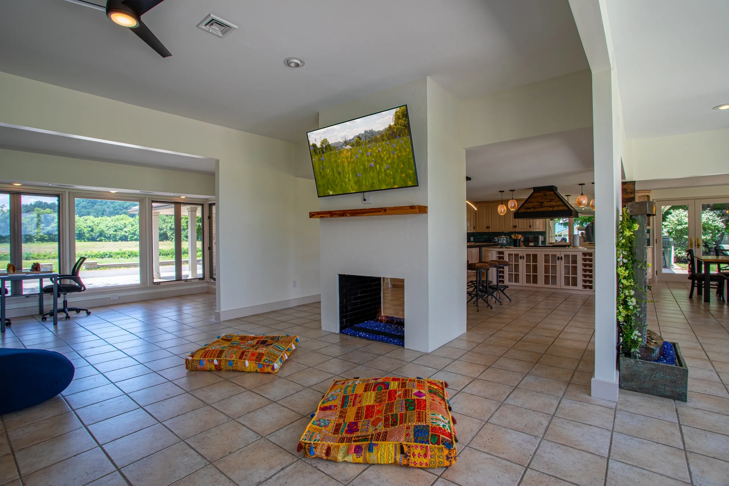 Spacious living room with colorful floor cushions.