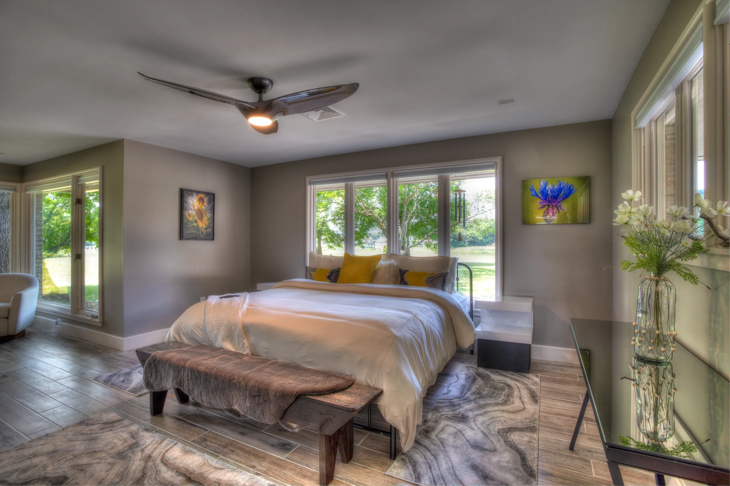 Modern bedroom with large windows and decor.