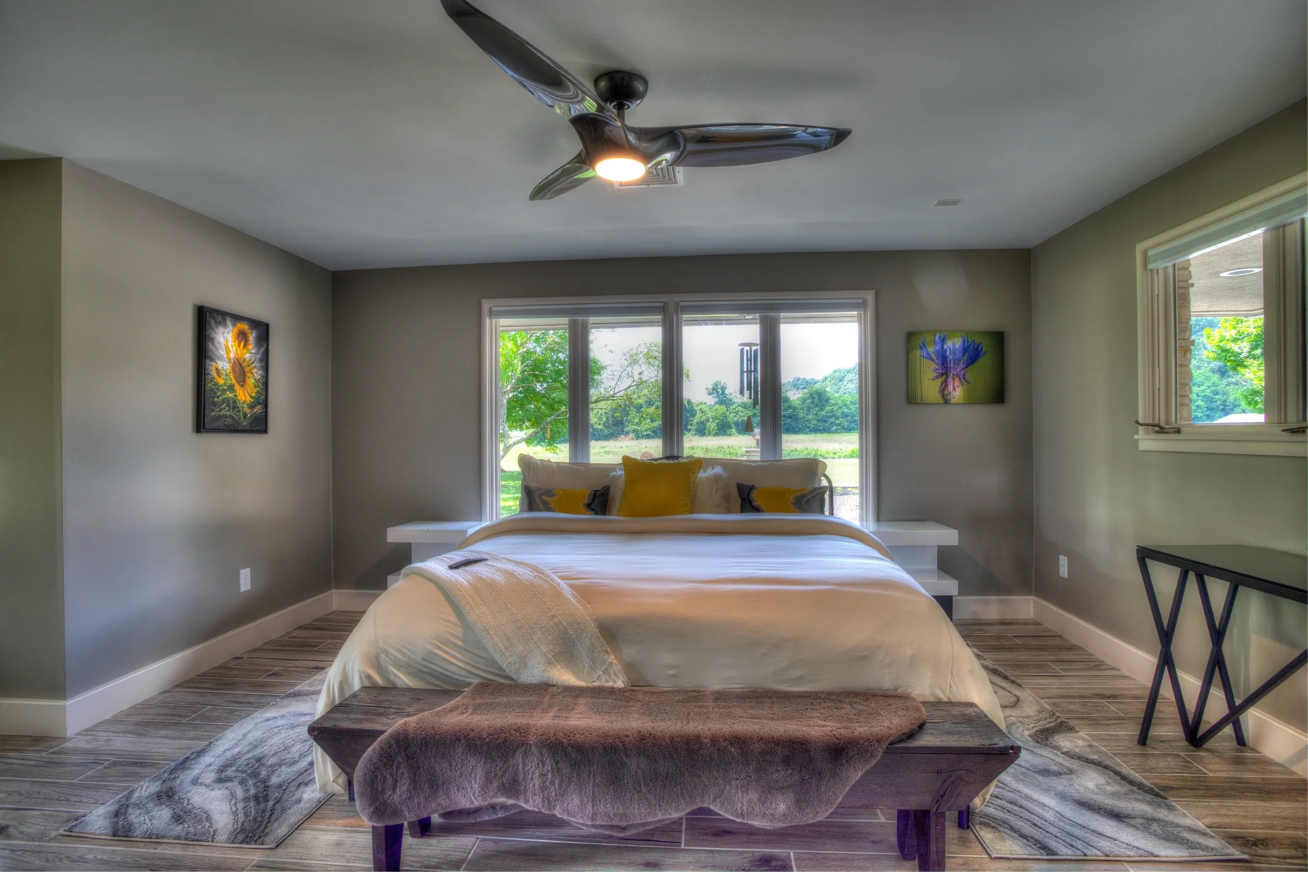 Modern bedroom with large bed and artwork.