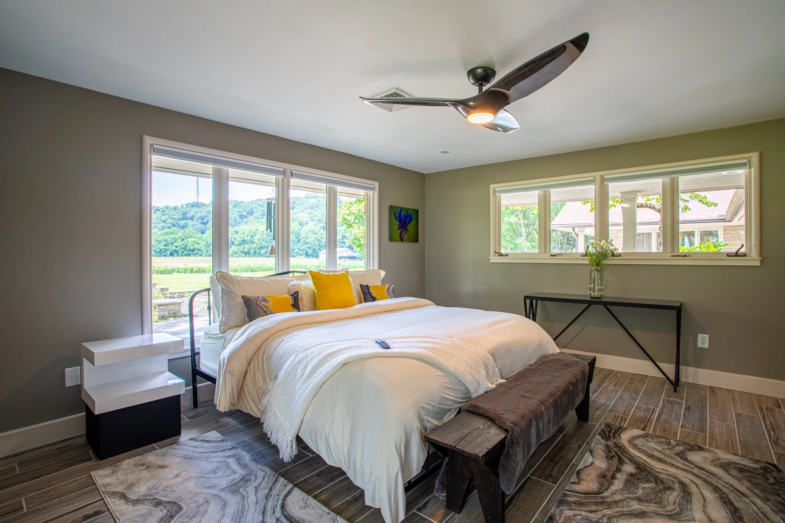 Modern bedroom with large windows and bed.