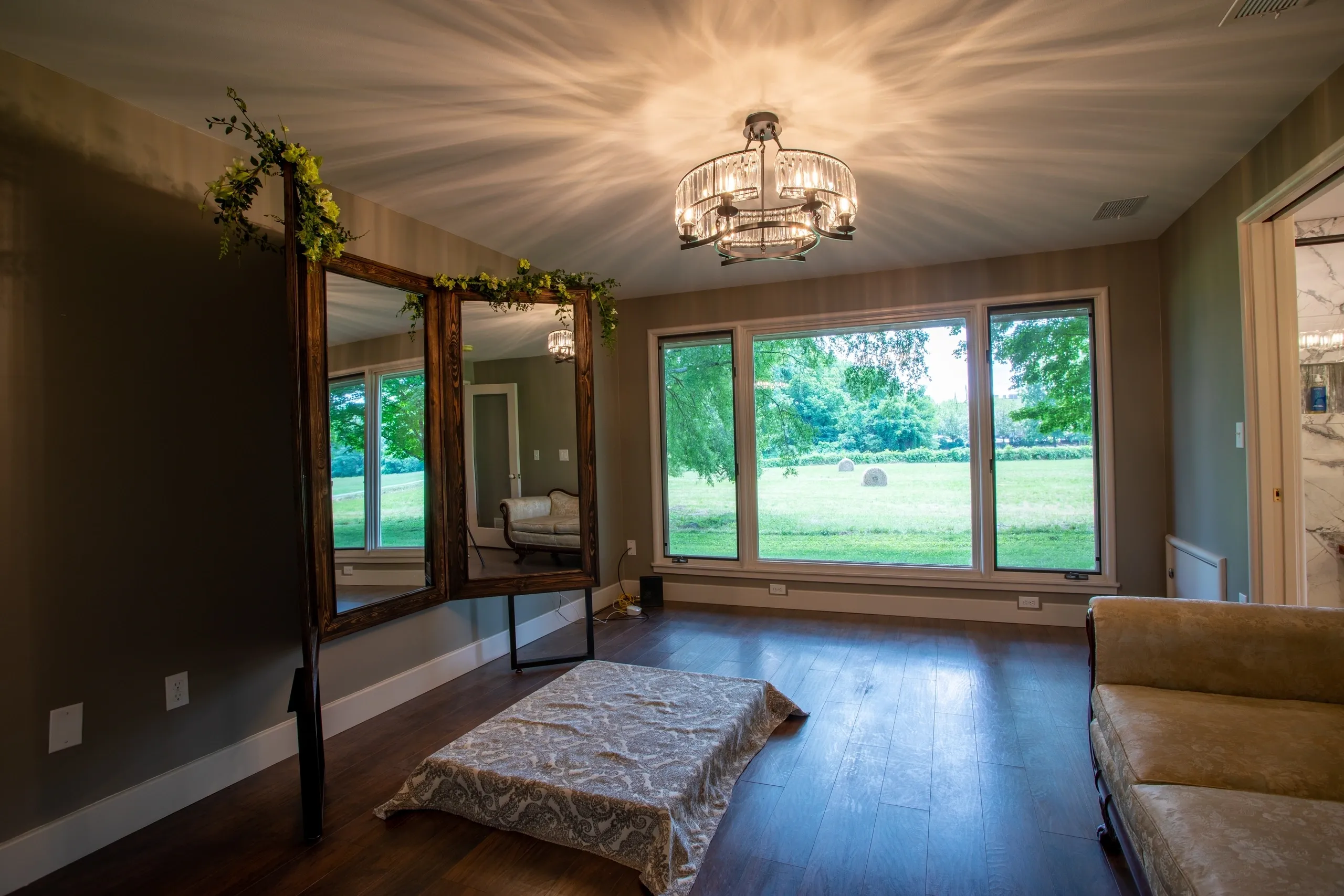Elegant room with large windows and mirror.