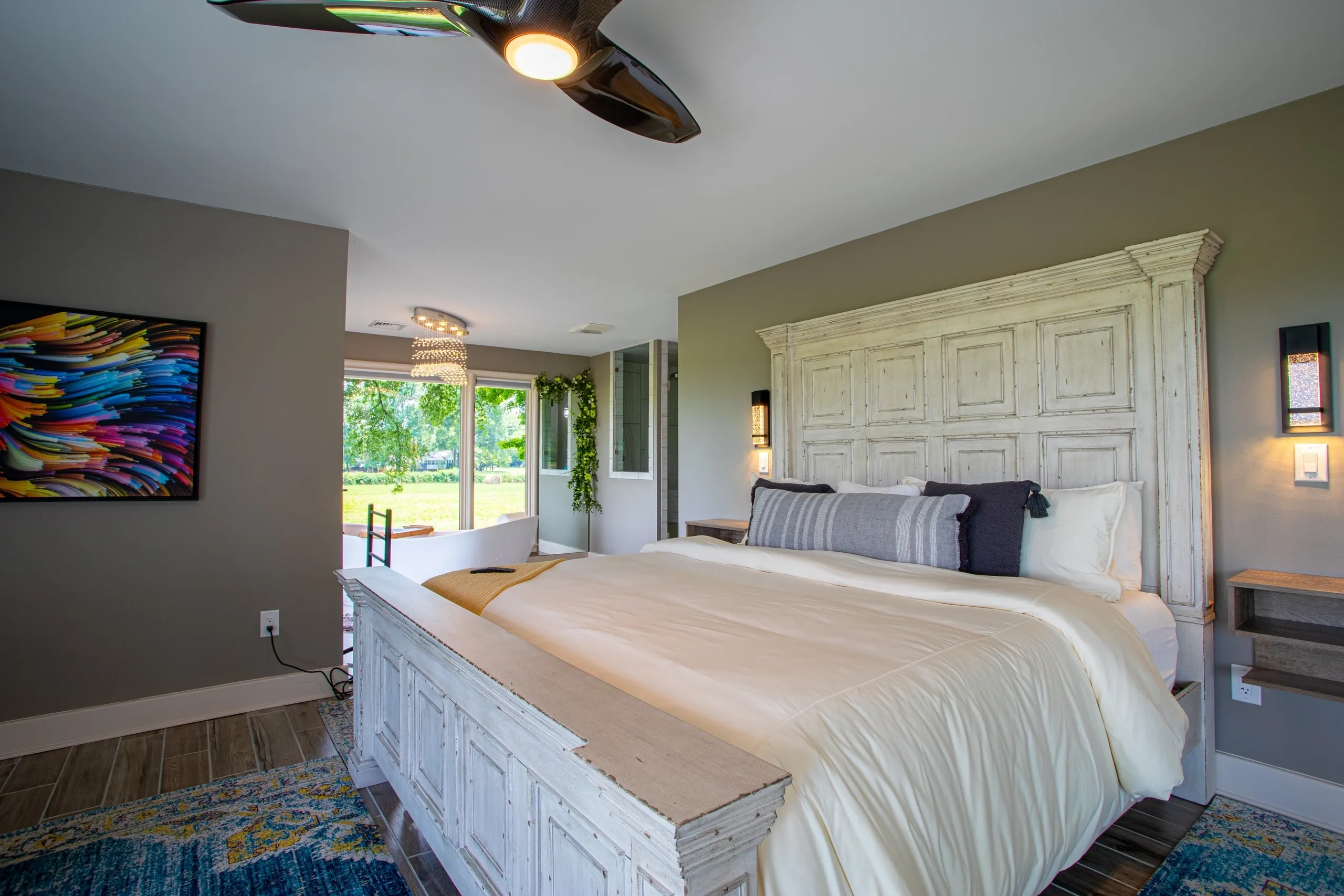 Modern bedroom with large bed and artwork.