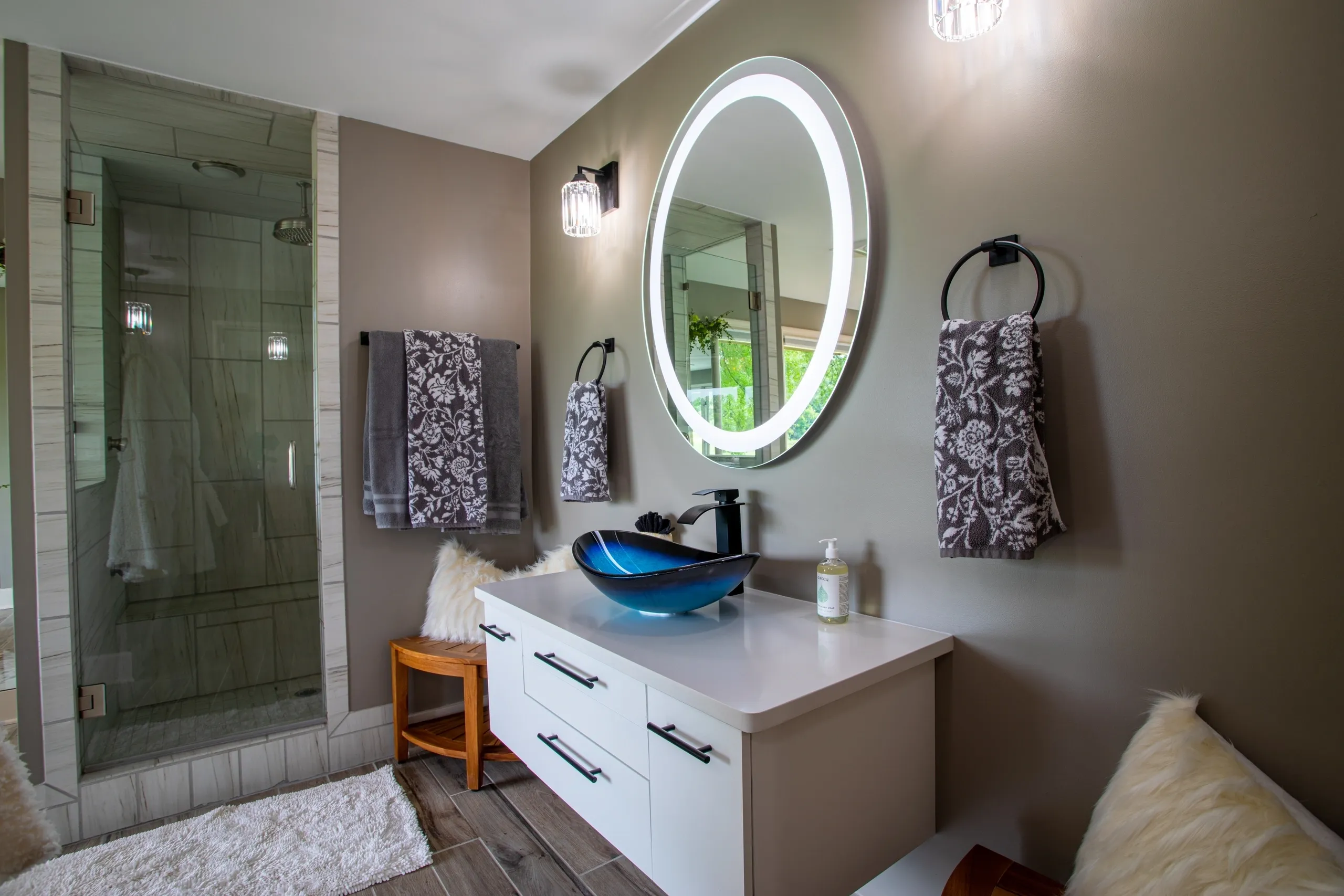 Modern bathroom with illuminated mirror and sink.