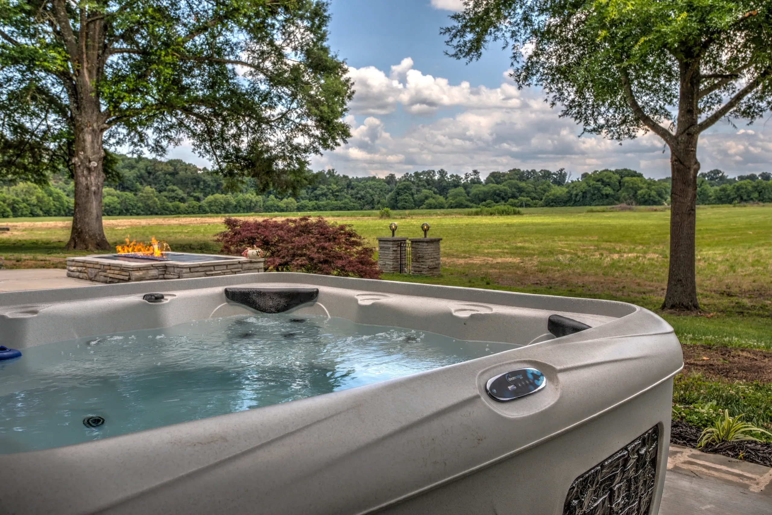 Hot tub overlooking scenic field and trees.