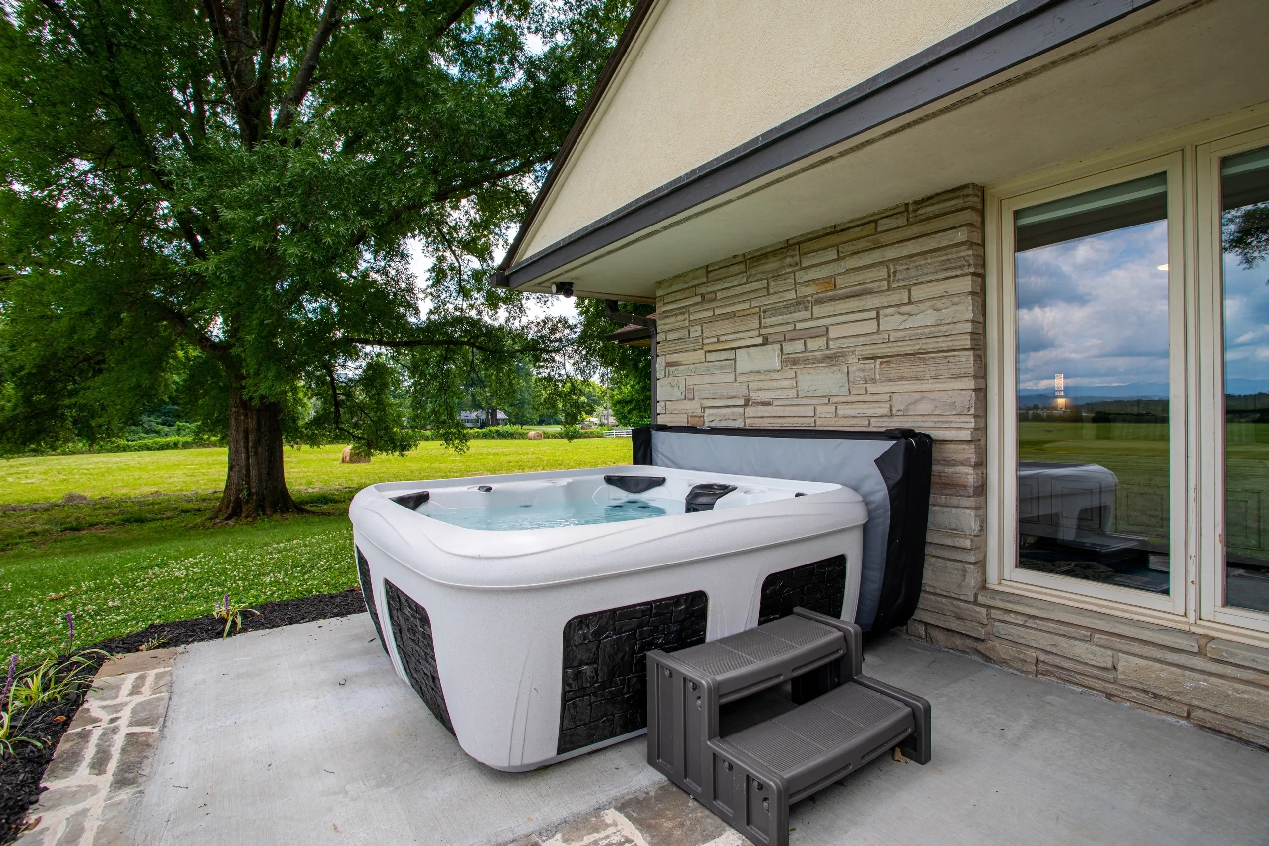 Outdoor hot tub on patio near house.