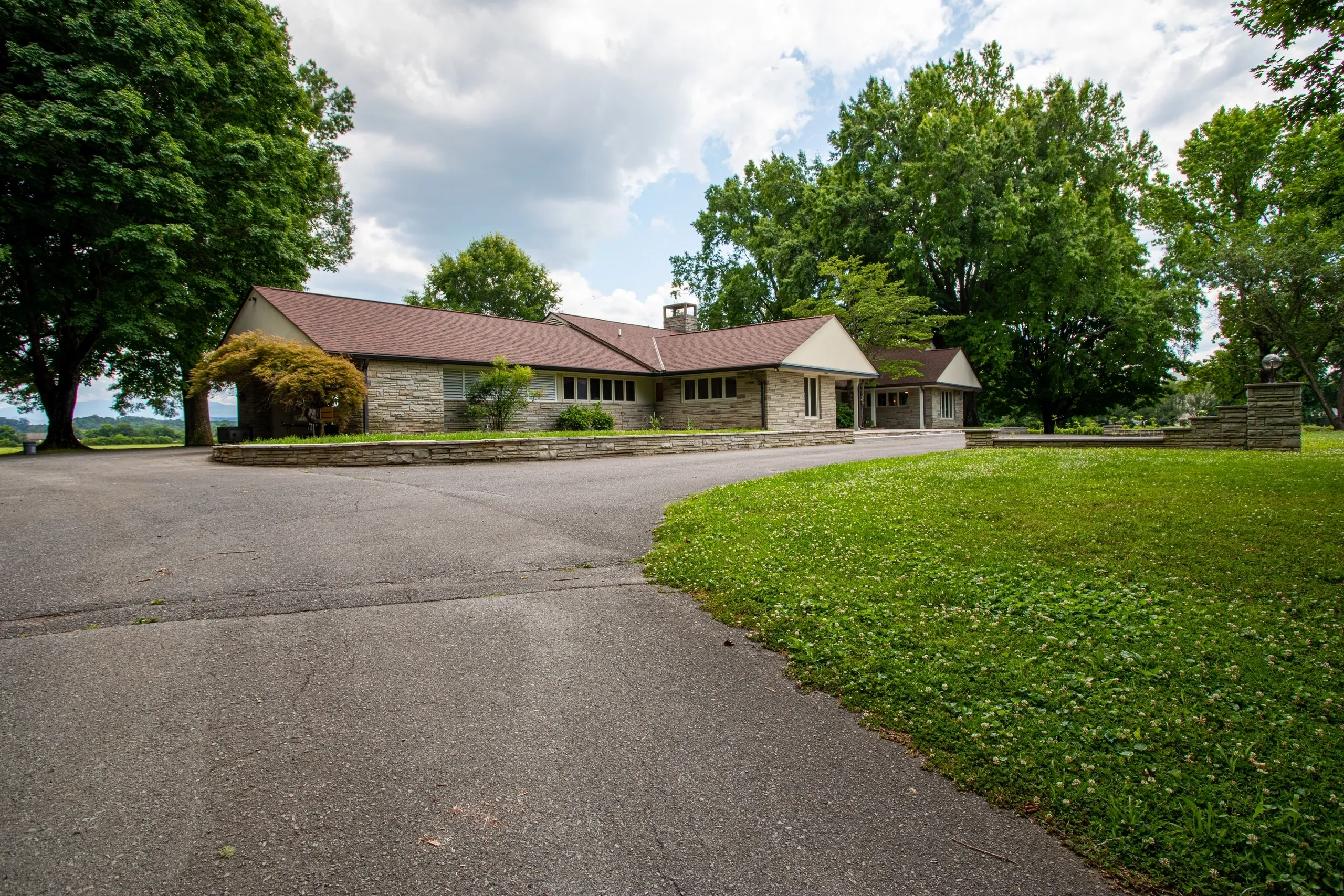 Large house with trees and driveway.