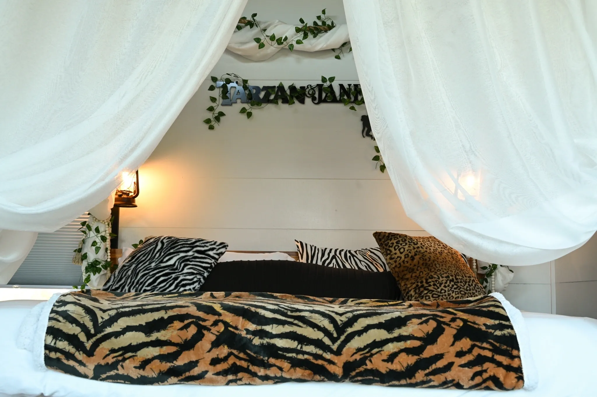 Bed with animal print decor and drapes.