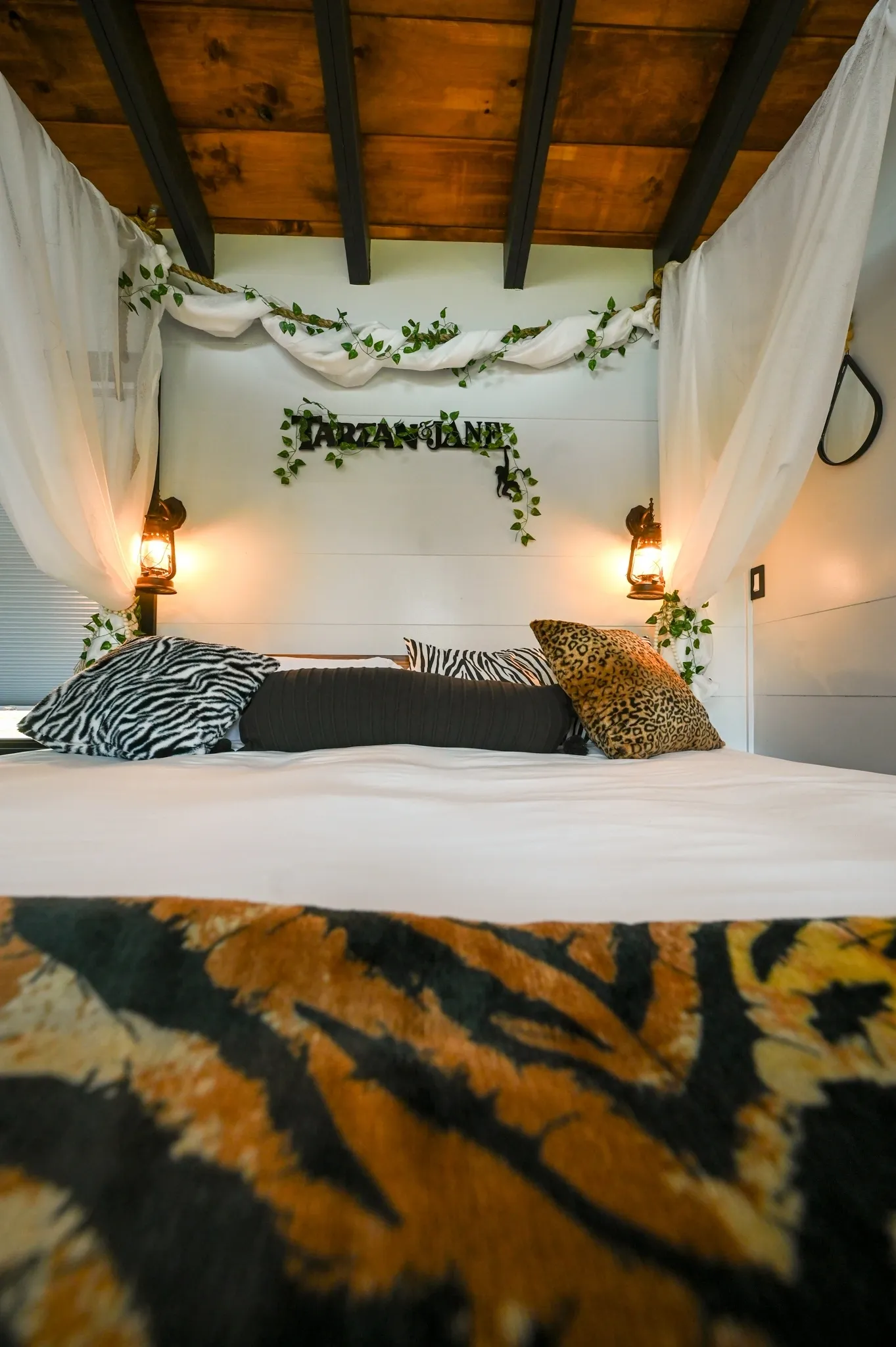 Jungle-themed bedroom with canopy and pillows.