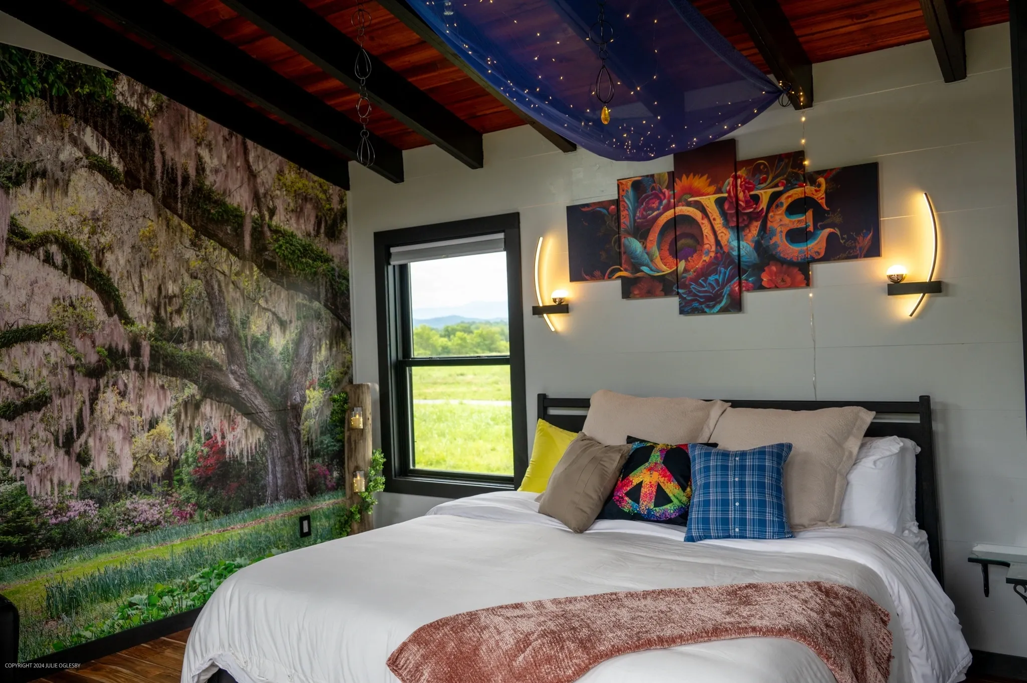 Cozy bedroom with nature mural and decor.
