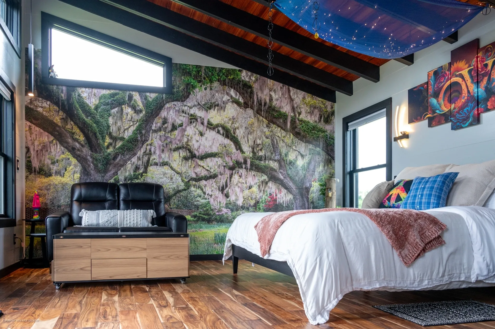 Modern bedroom with nature-themed wall mural.