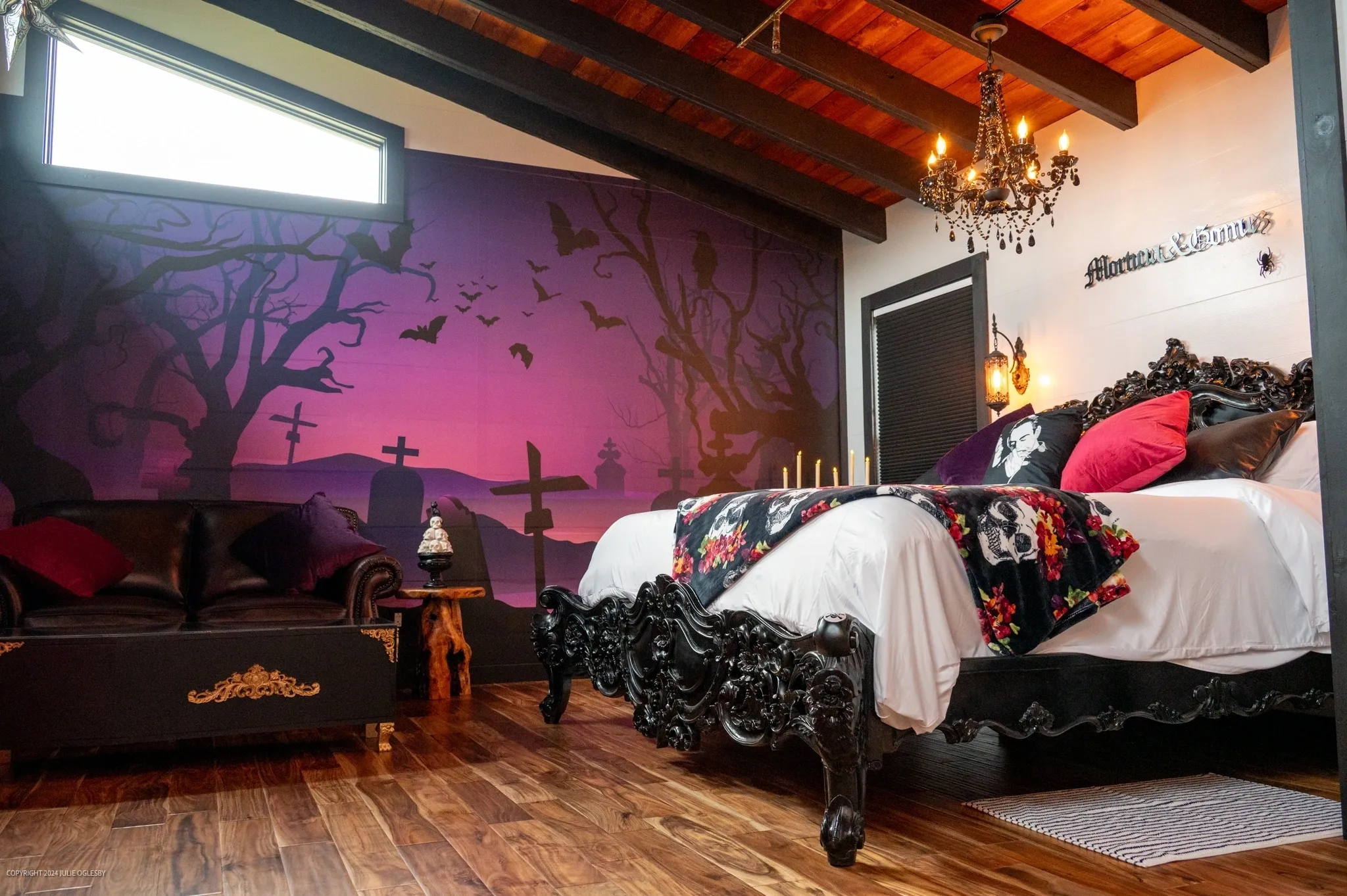 Gothic bedroom with chandelier and purple mural.