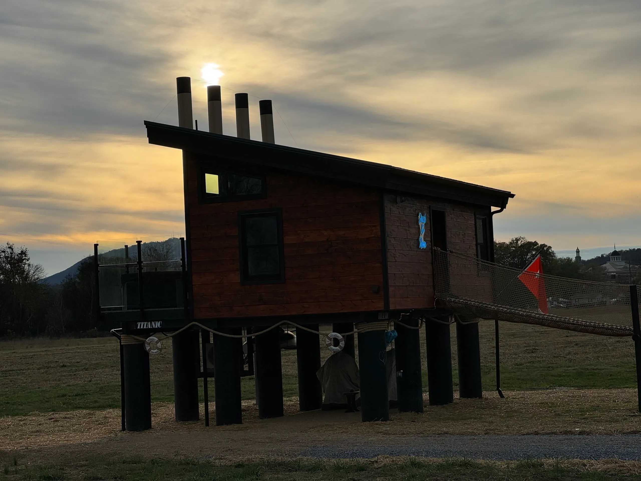 Elevated wooden cabin against a cloudy sunset.