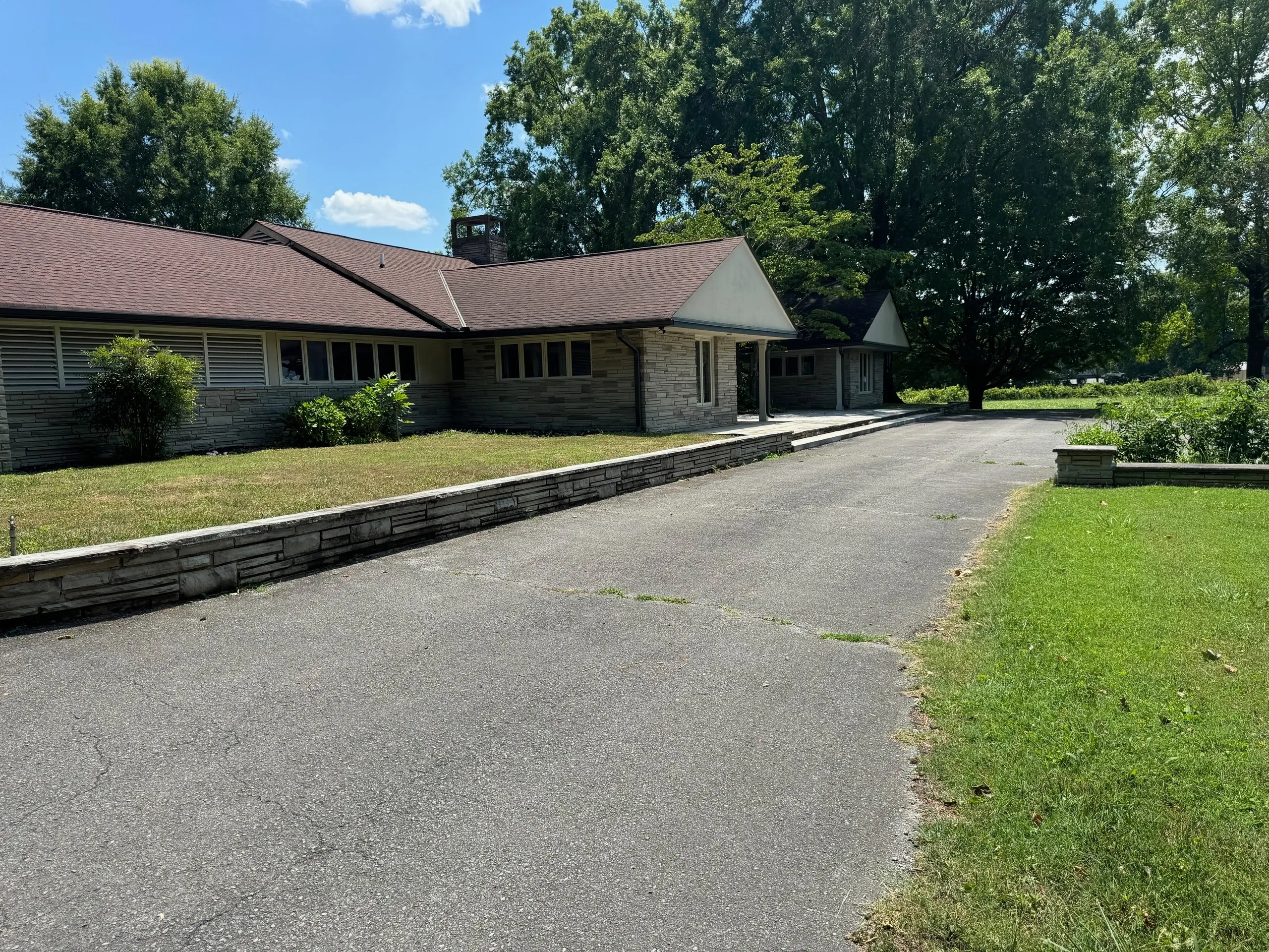 Single-story house with driveway and trees.