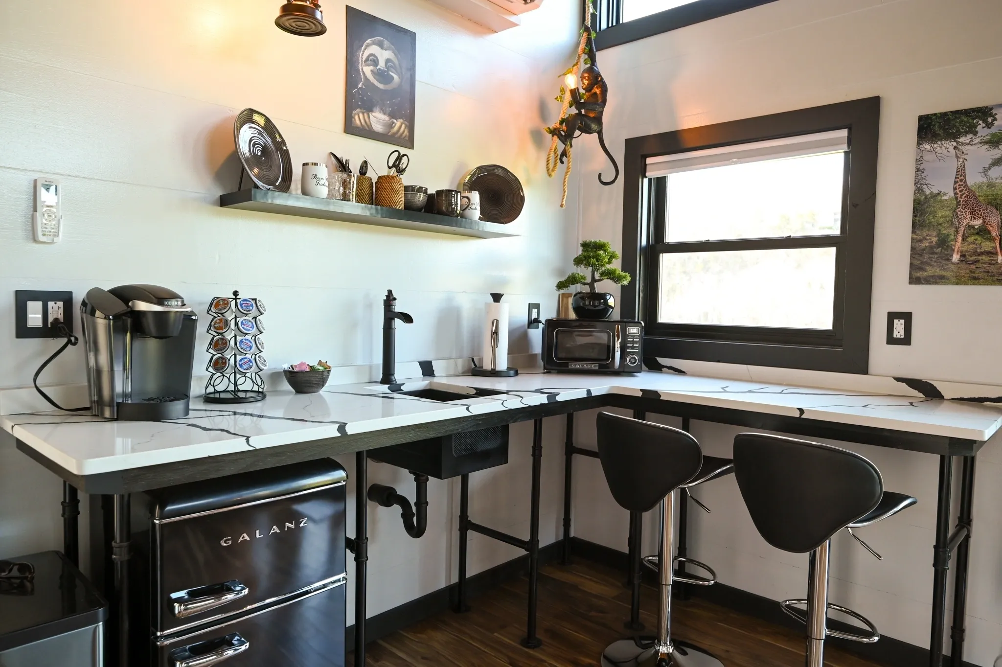 Modern kitchen with stools and appliances.
