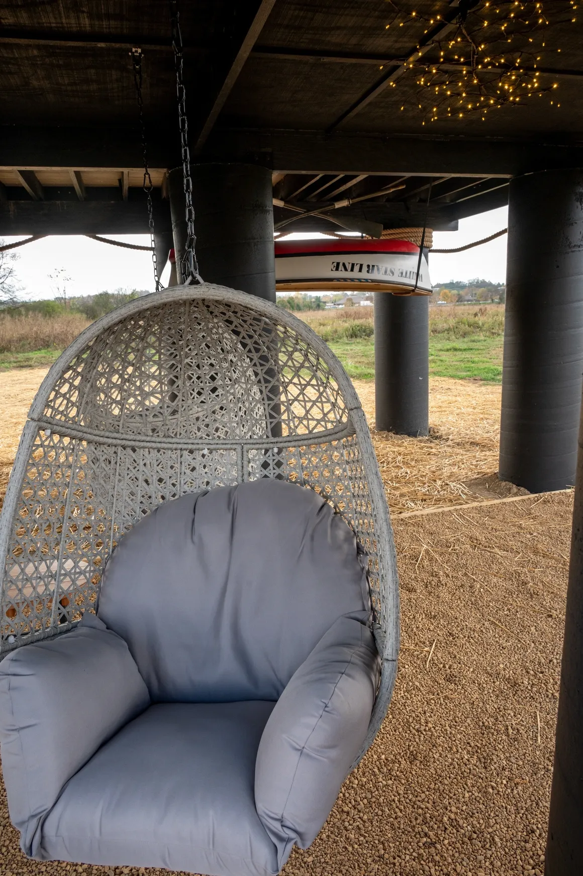 Hanging chair under deck with lights.