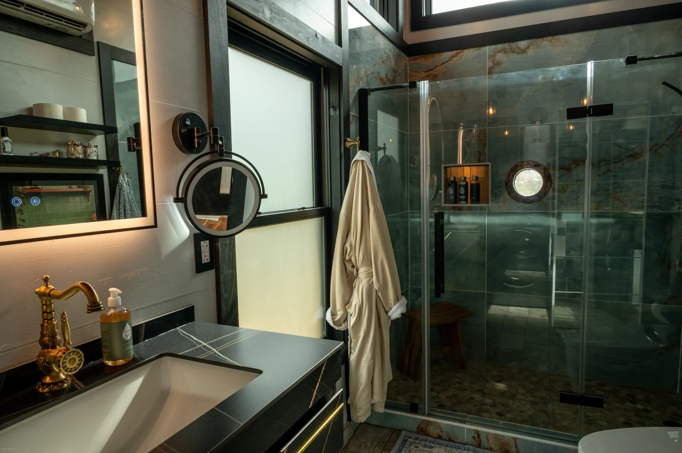 Modern bathroom with glass shower and robe.
