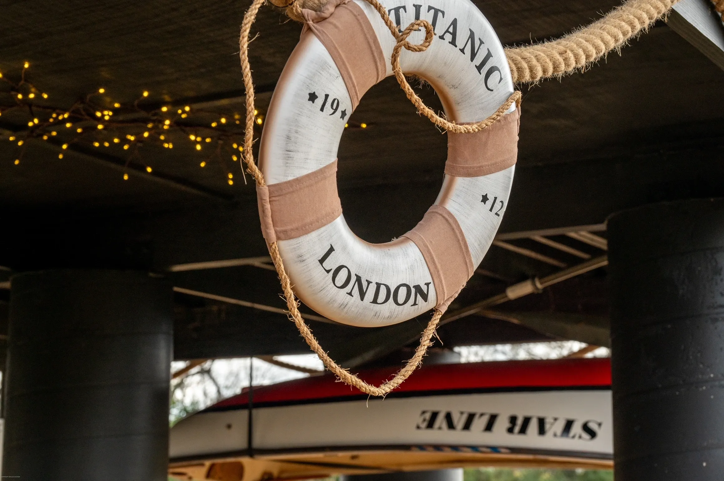 Lifebuoy labeled "Titanic London" hanging indoors.