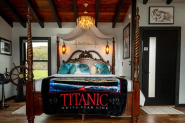A bed with a titanic poster on it.